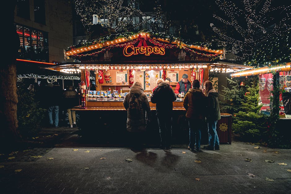 Illuminated crepes stall at a bustling Christmas market in Germany.