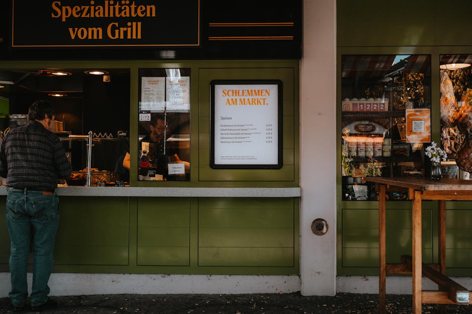 Cozy market stall with vibrant signage and customer in a bustling European street.